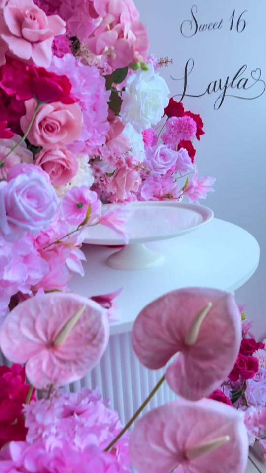Pink floral installation with cake stand and personalised Sweet 16 signage